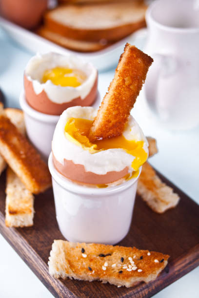 istock boiled egg in eggcup on wooden board with crispy toast. 1308639139
