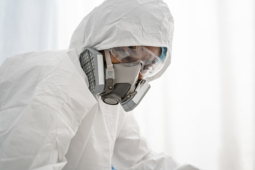 I save your lives. Portrait view of the medical worker wearing protective equipment preparing to treating patients with coronavirus at the hospital. Stock photo