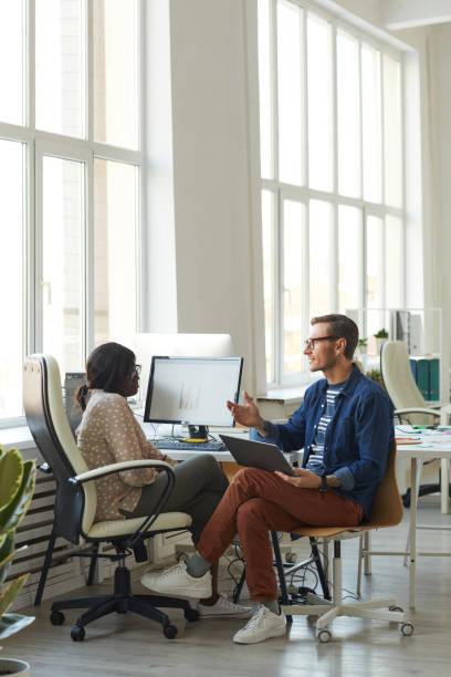 istock Project Manager Instructing Female Employee in Office 1308639727