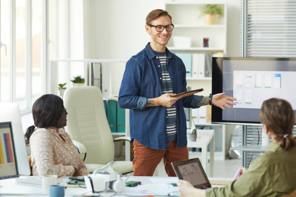 istock Smiling Team Leader Presenting at Meeting 1308639751