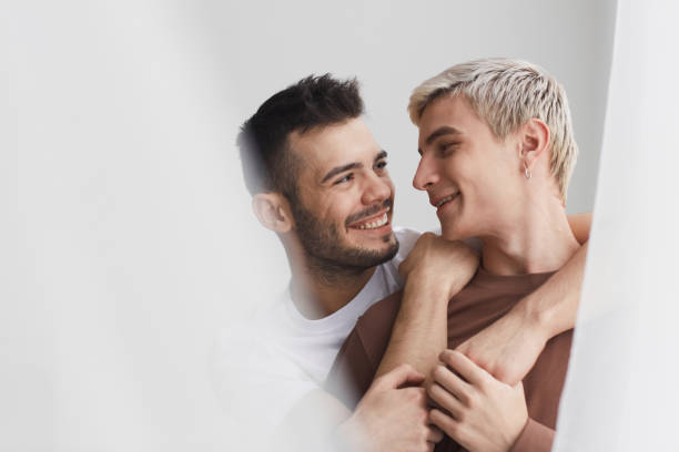 coppia gay spensierata che abbraccia - gay man homosexual couple homosexual men foto e immagini stock