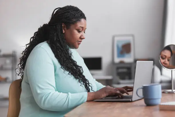 Photo of Overweight African American Woman Using Computer Side View