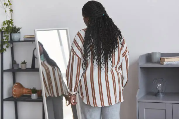 Photo of Overweight African American Woman Looking in Mirror Back View