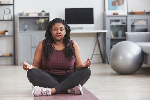 Overweight African American Woman Meditating at Home
