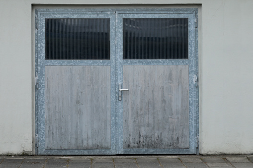 Stonewall facade with beautiful metal garage door with windows, no person and space for text,shutter closed and looks like industrial building, no person and space for text