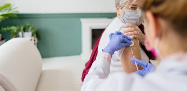 istock Senior woman's getting vaccinated at her home 1308642597