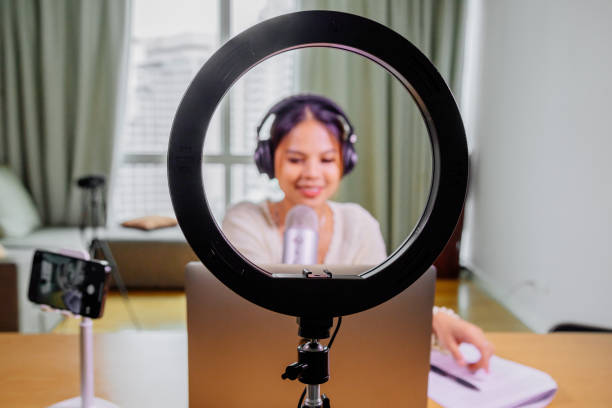 istock Asian blogger, podcaster or vlogger looking at camera and talking on video shooting with technology. Social media influencer people or content maker concept in relax casual style at home 1308642670