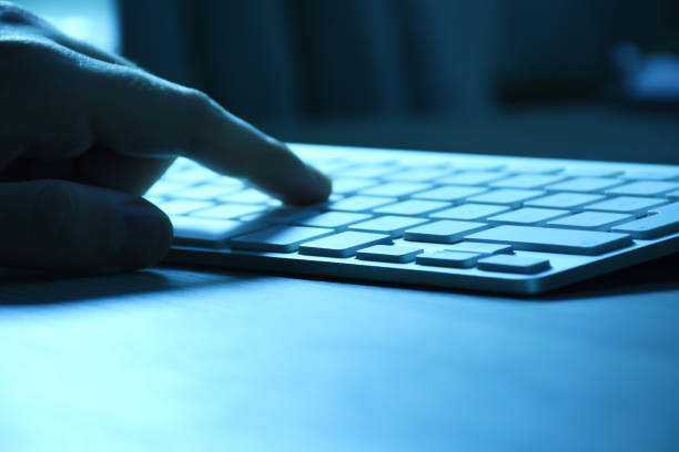 istock Men's hand using computer in the dark on the desk with copy space 1308644437