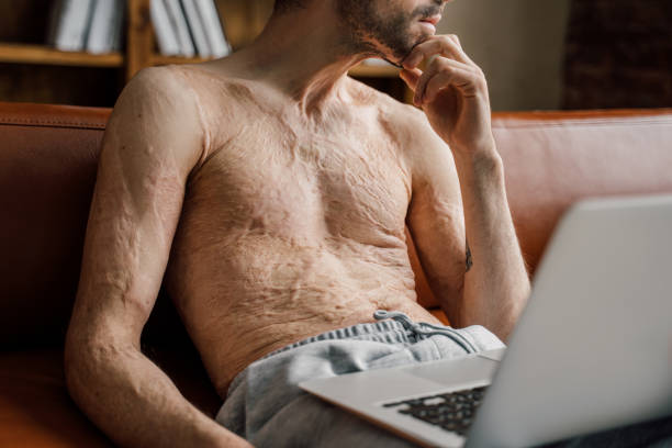 istock Man using laptop at home and looking at the window at home 1308645943