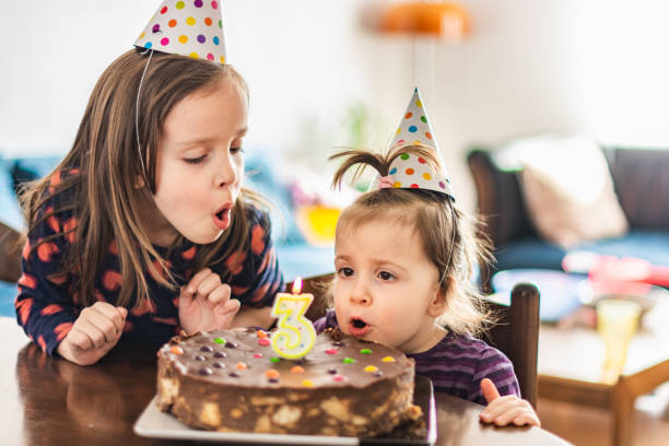 istock Children blowing birthday candle 1308647617