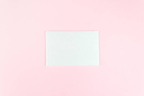 istock Square invitation card mockup on a soft pink background. Flat lay, top view, copy space. 1308650068