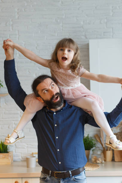 istock Happy little daughter sitting on father neck 1308650113
