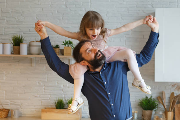 istock Happy little daughter sitting on father neck 1308650162