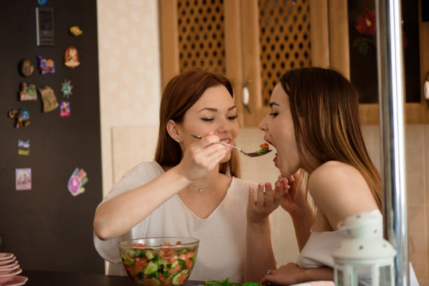 istock Young sisters making vegetable salad at home. 1308651539