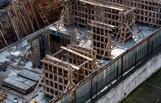 Strengthening the gaps surrounded by steel bars and wooden planks during construction by pouring concrete.