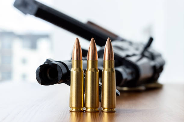istock Three bullets against blurred Kalashnikov assault rifle background. Cartridges 7.62 caliber for ak 47 closeup 1308652060
