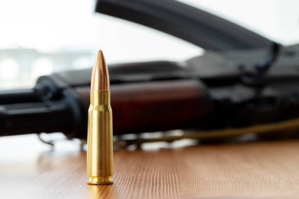 istock One bullet against blurred Kalashnikov assault rifle background. Cartridge 7.62 caliber for ak 47 closeup 1308652581