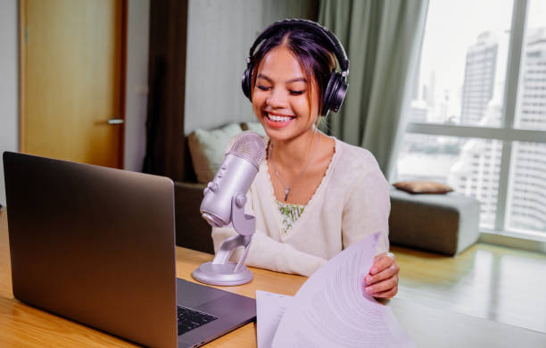 istock Asian blogger, podcaster or vlogger looking at camera and talking on video shooting with technology. Social media influencer people or content maker concept in relax casual style at home 1308652901