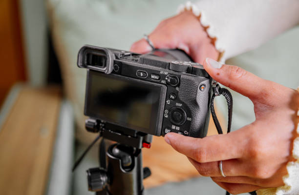istock Asian female blogger setting up her digital camera before making a new video for vlog 1308654545