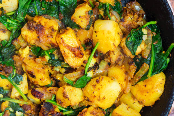 istock Saag Aloo, Indian style spinach and potatoes in cast iron pan 1308654554