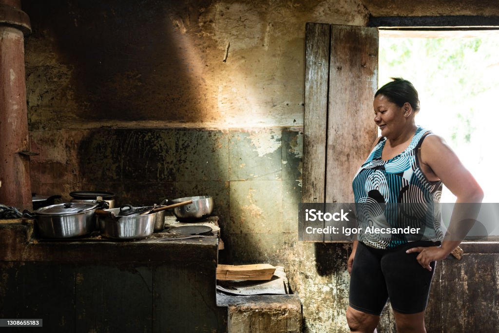 Woman at wood stove Housewife cooking on wood stove Poverty Stock Photo