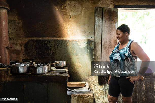 Woman At Wood Stove Stock Photo - Download Image Now - Poverty, One Woman Only, Cooking