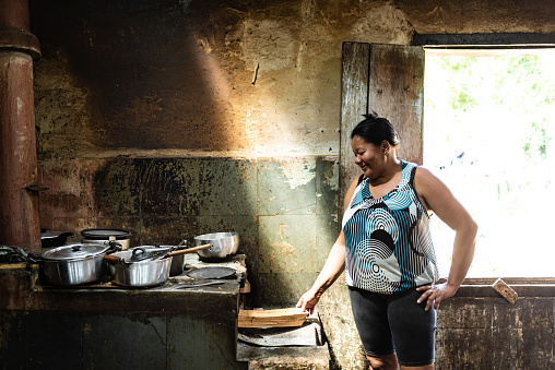 Brazilian woman in the kitchen lighting the wood stove