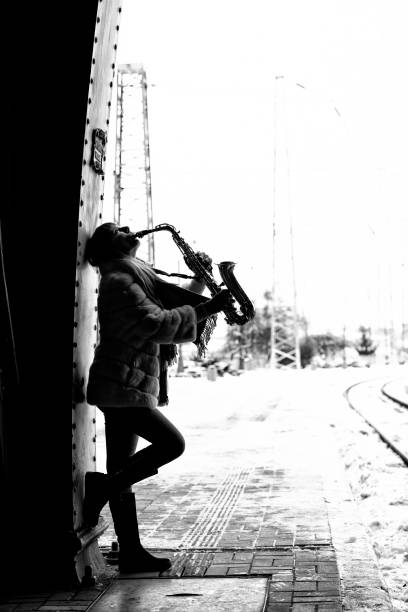istock Beautiful woman playing saxophone 1308655504