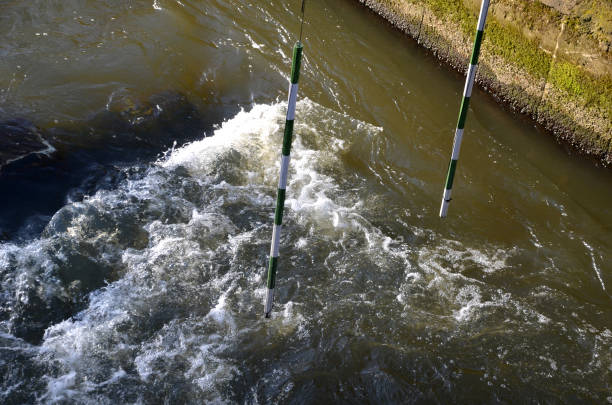 objectifs de slalom de course pour canoë et radeau, kayak. piste de course avec barres rayées suspendues sur une rivière sauvage et calme. à la fois débutant et avancé paddler ride - rapid water rafting artificial photos et images de collection