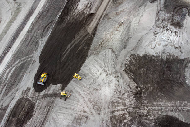 istock Bulldozer and trucks on a disposal site - aerial view 1308657659