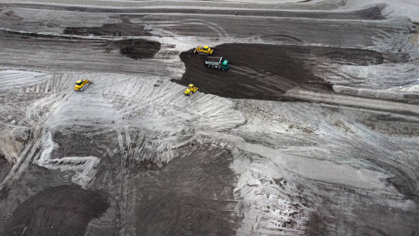 istock Bulldozer and trucks on a disposal site - aerial view 1308657678