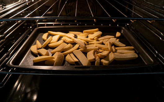 Frozen fries being baked in an oven