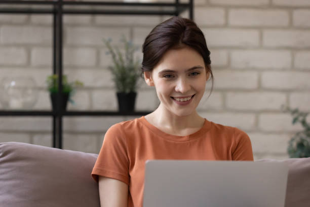 istock Close up smiling woman using laptop, chatting online at home 1308658884