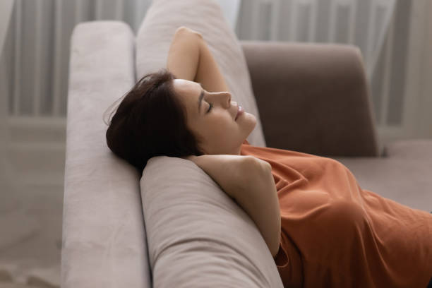 istock Close up peaceful young woman leaning back on cozy couch 1308658904