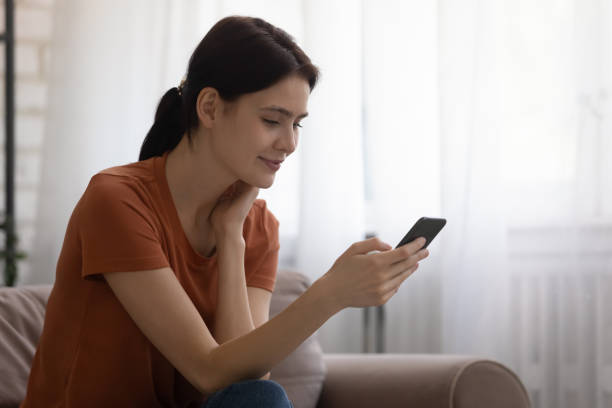 istock Close up attractive young woman using phone at home 1308658910