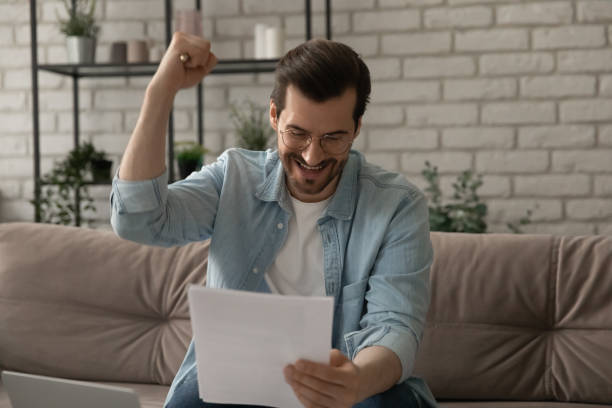 istock Close up overjoyed man reading good news in letter 1308658949