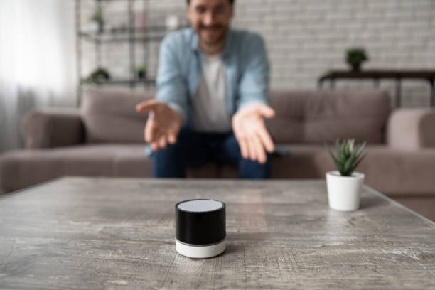 istock Close up man talking to wireless smart speaker at home 1308658974