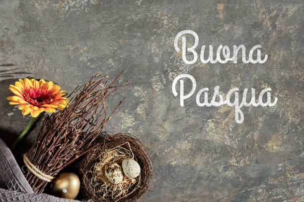istock Easter decorations, text Buona Pasqua means Happy Easter in Italian language. Gerbera flower, quail eggs in nest, twigs, Spring arrangement on textured background. Italian Easter greeting card design 1308660517