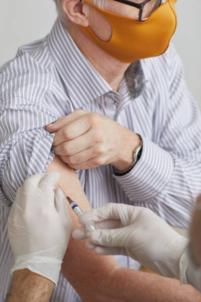 istock Doctor Vaccinating Senior Man Close Up 1308661590