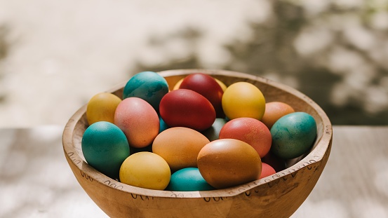 Close-up of Easter basket with colourful eggs on natural background