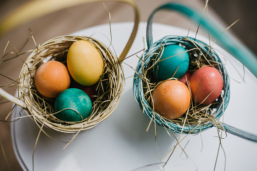 Two nests with colourful Easter eggs on the table prepared to be given