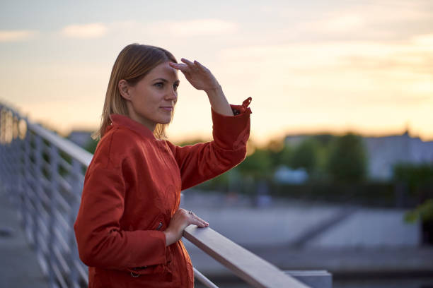 belle femme regardant vers l’avant avec la main dans le front au coucher du soleil - front view photos et images de collection