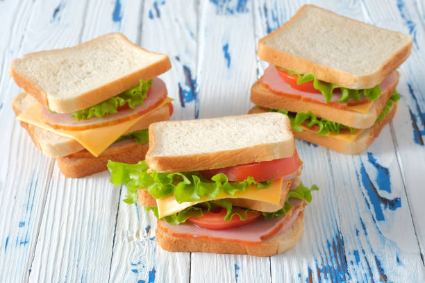 istock Three tasty sandwiches on rustic wooden background 1308664003