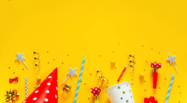 Happy birthday background: party hat, serpentine, stars, cocktail tubes, candles, blower on a yellow background. Happy birthday background: party hat, serpentine, stars, cocktail tubes, candles, blower on a yellow background. Holiday concept. Copy space Banner. confetti star shape red yellow stock pictures, royalty-free photos & images