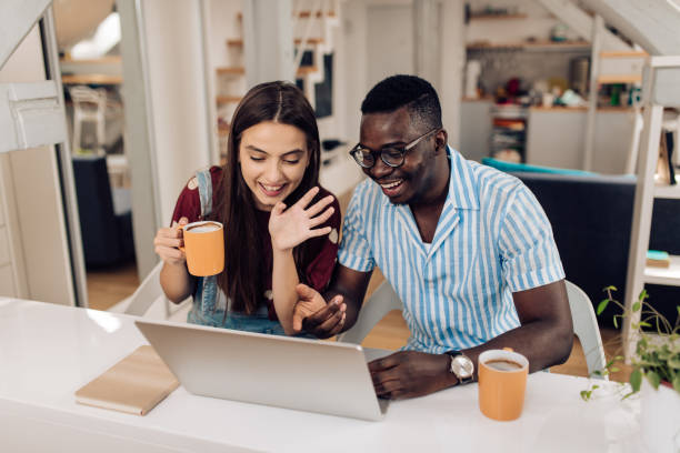 istock Happy couple of students having an online class from home 1308669952