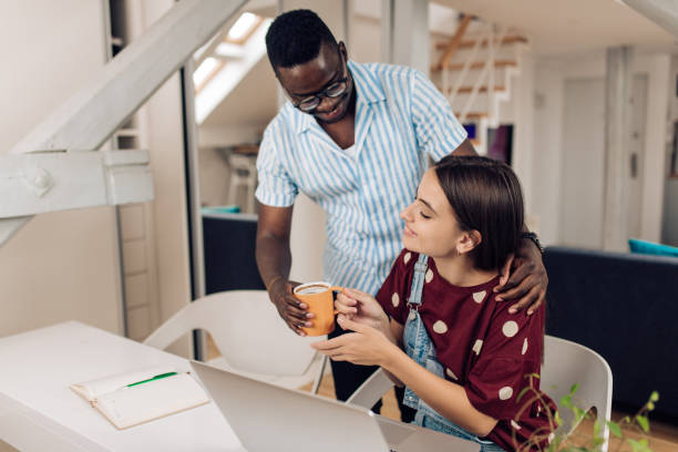 istock African American young man bringing coffee to his girlfriend while studying 1308669960