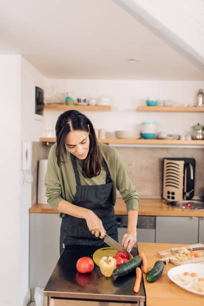 istock Woman chopping veggies to make a takeaway meal 1308670175
