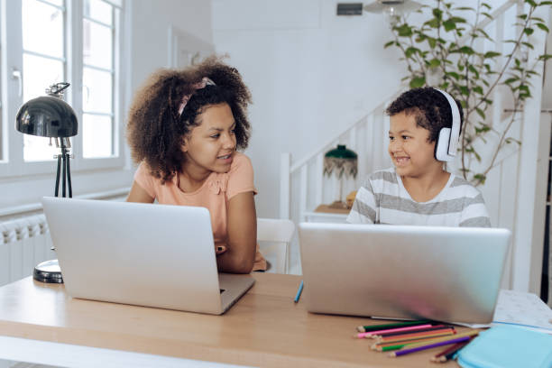 istock Cute brother and sister learning online at home 1308670262