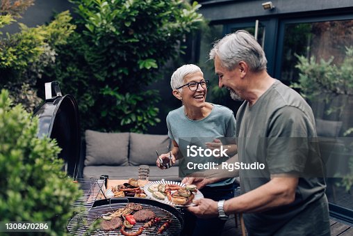 istock Senior couple grilling meat and enjoying in the backyard 1308670286