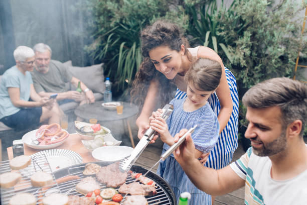 istock Girl making barbecue with her mom and dad 1308670338